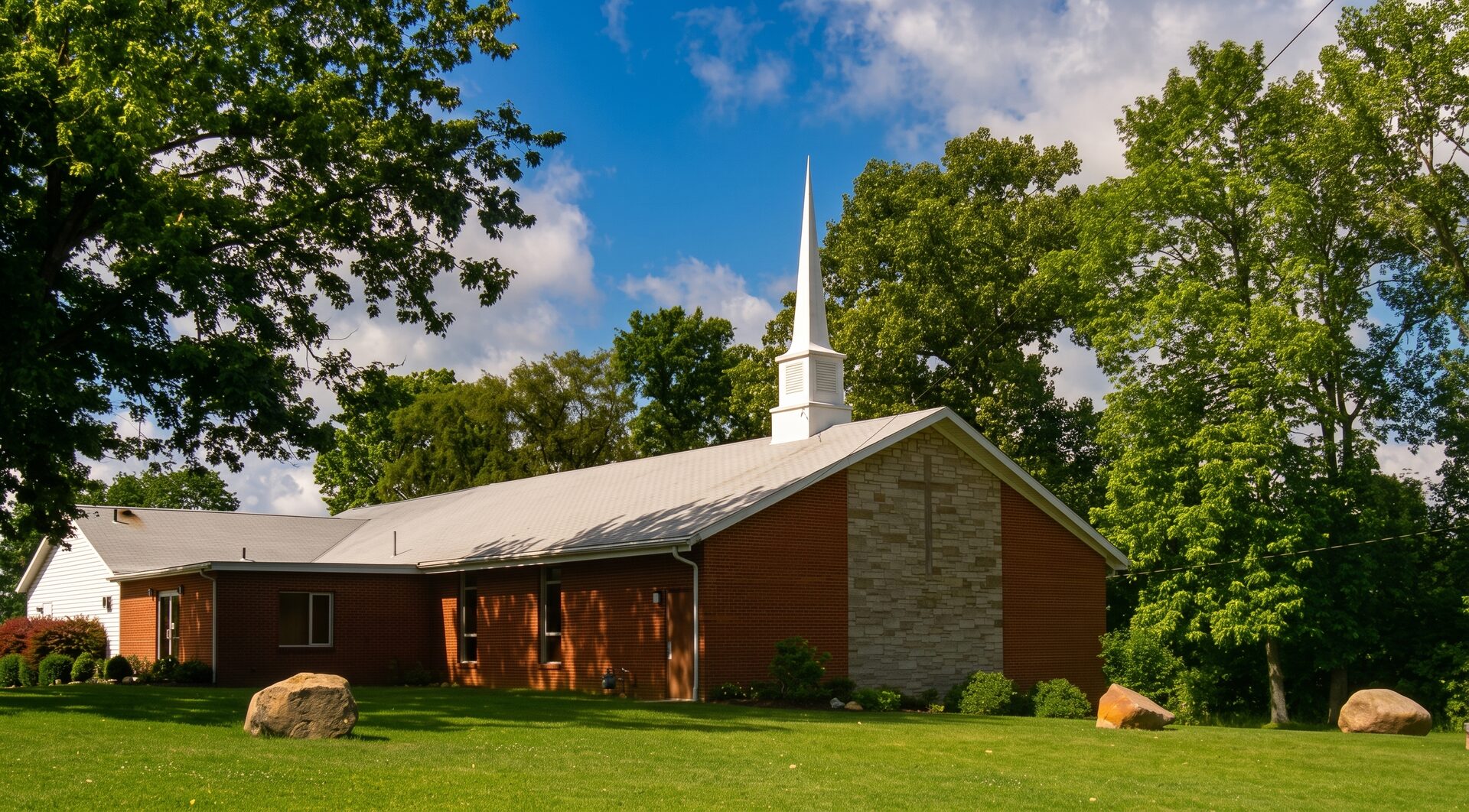 The River Amherst church building, white steeple against a summer sky