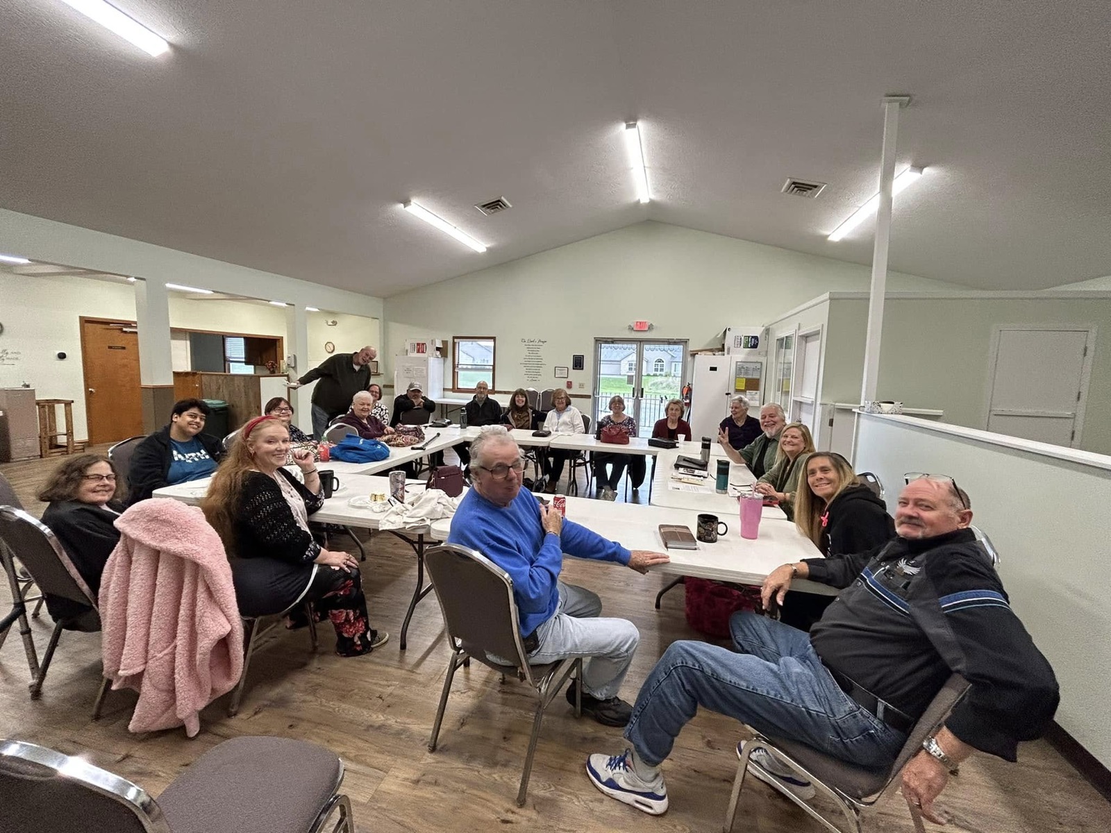 The River Amherst congregation around tables in the fellowship hall